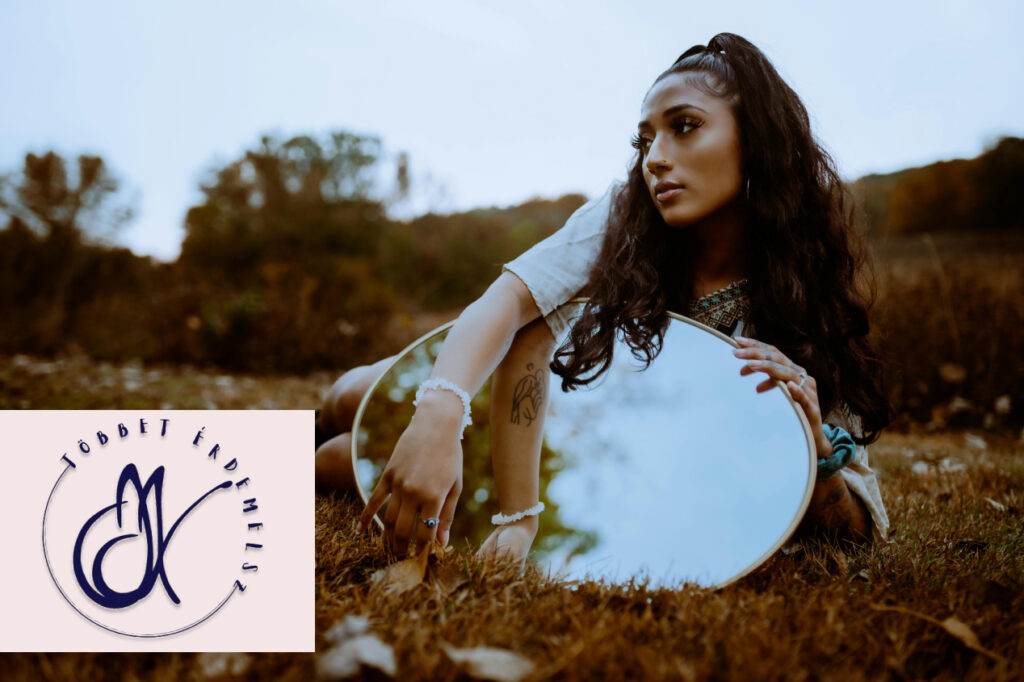 Önismeretre utaló kép: egy nő tükörrel a kezében fekszik a szabadban, némi félelmet mutatva